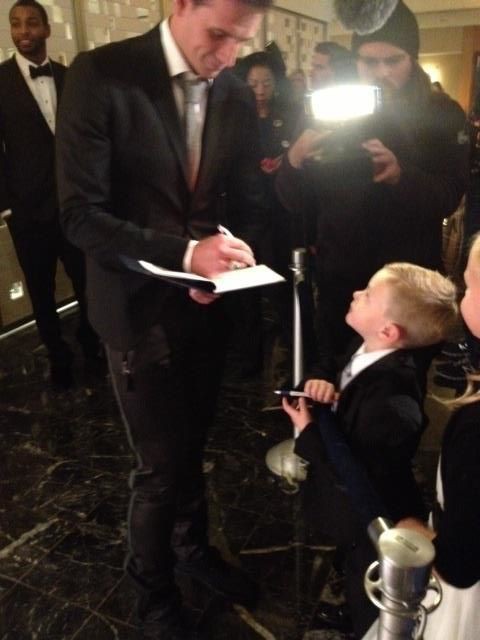 Ryan signing autograph to a kid fan at The Golden Goggle Awards
