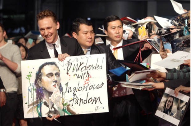 Tom showing a painting of him made by his fan